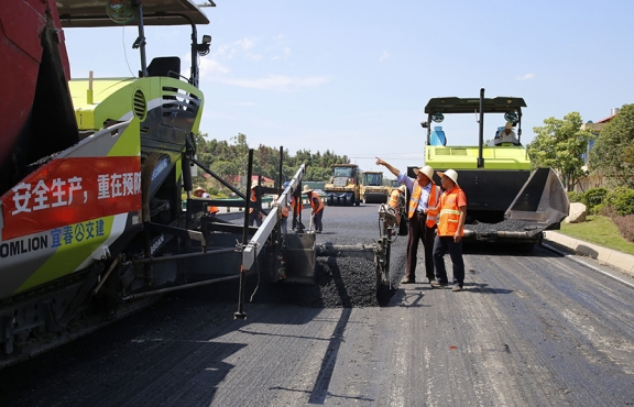 攤鋪機(jī)、壓路機(jī)等設(shè)備緊張有序運(yùn)行，高達(dá)170℃的瀝青混合料炙烤著公路人